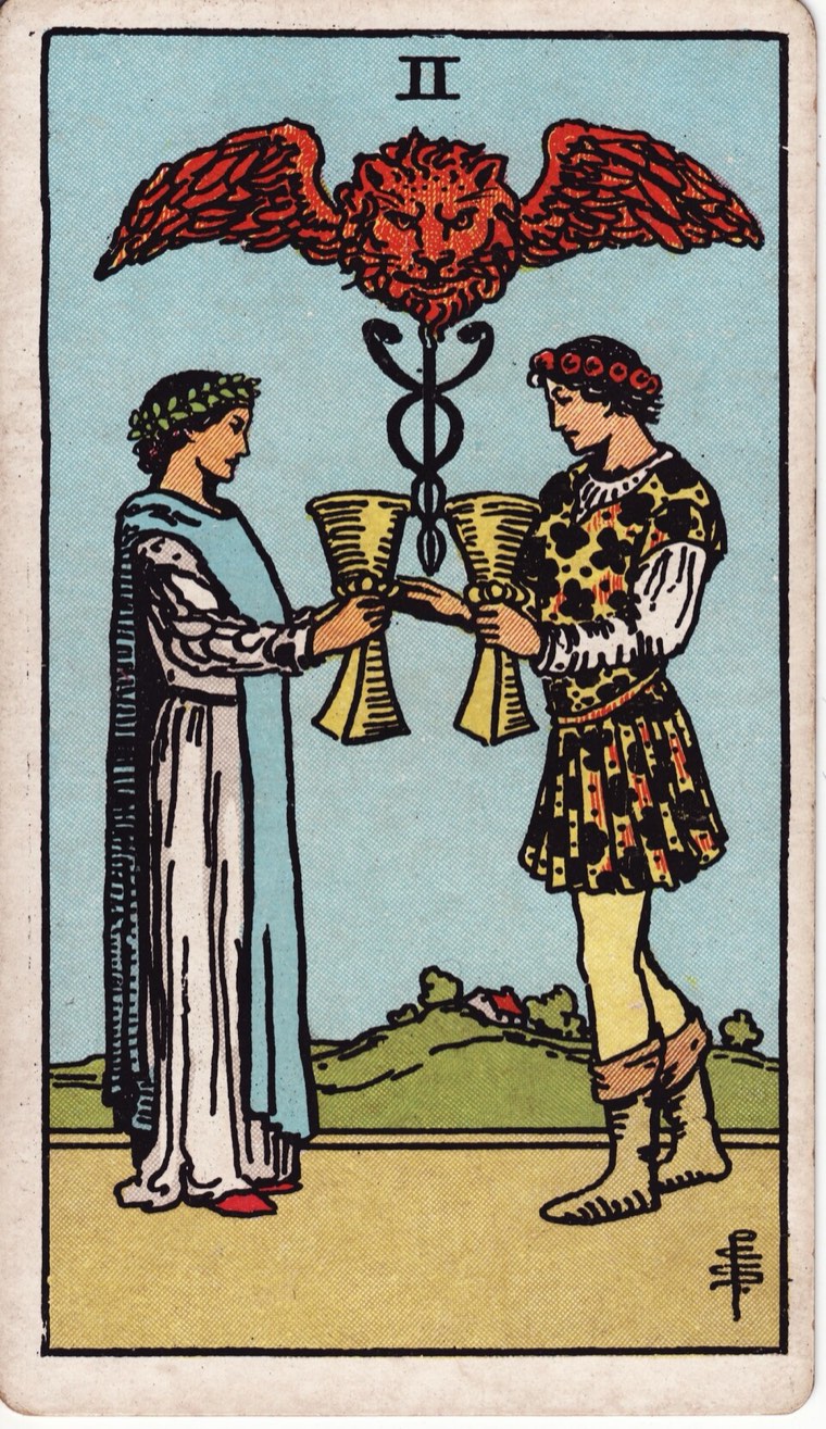 Two of Cups in the Waite–Smith 1909 deck: two equal participants, mutual exchange, paired cups, binding or healing symbol