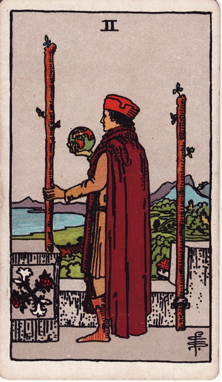 Two of Wands in the Waite–Smith 1909 deck: figure holding or considering a world beyond, one wand held and one anchored or equivalent, elevated view