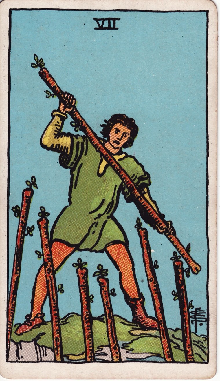 Seven of Wands in the Waite–Smith 1909 deck: one defender at advantage, multiple challenges below or around, active boundary